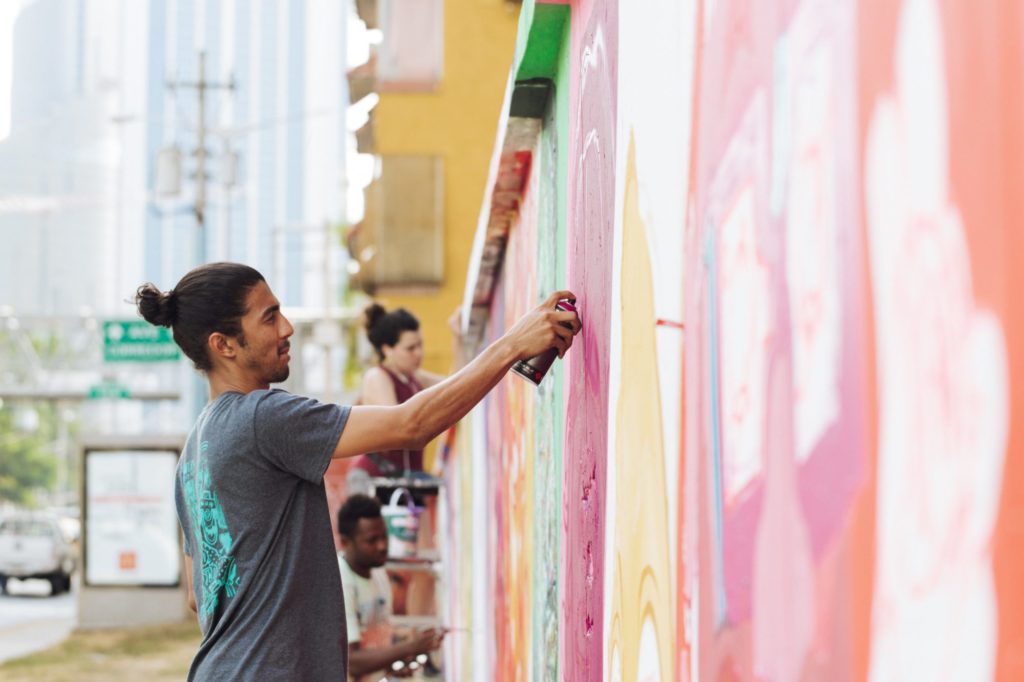 person spray painting a mural onto a wall